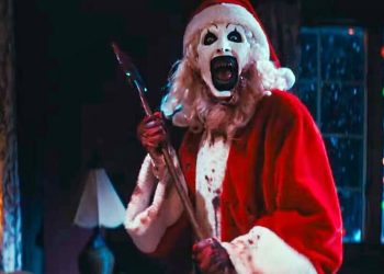 David Howard Thornton as Art the Clown holding an axe and laughing in Terrifier 3.