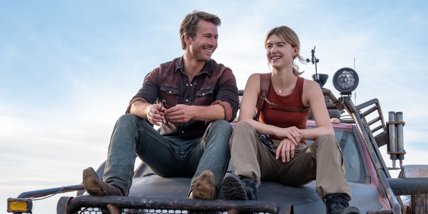 Glen Powell et Daisy Edgar-Jones assis au sommet d'un camion résistant aux tempêtes, souriants, comme Tyler et Kate.